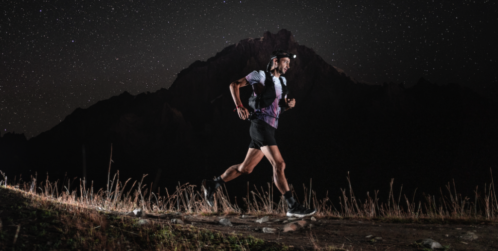 Un homme faisant du trail de nuit en montagne