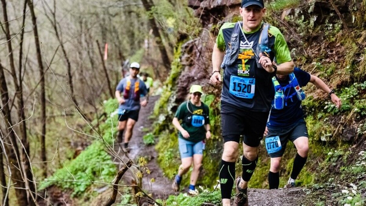Trail de 4 hommes habillés en tenue d trail avec des dossards